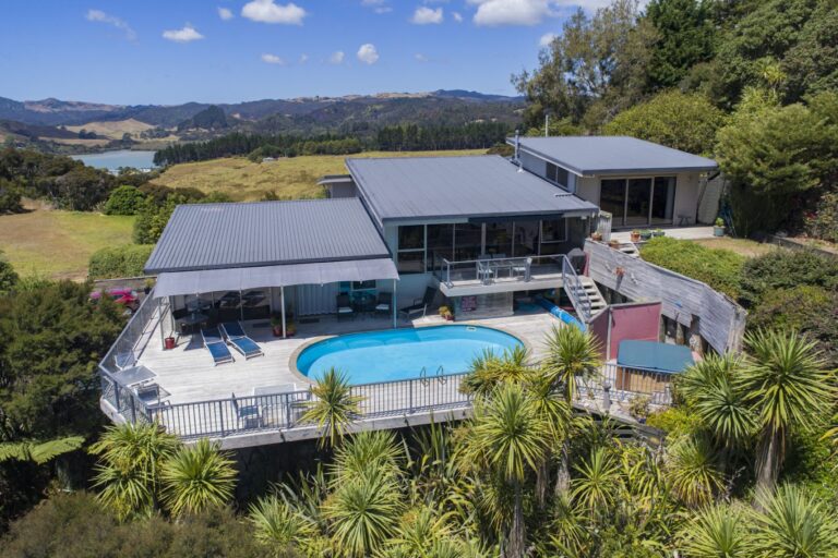 View of King's View Lodge pool deck and the surrounding native bush, overlooking Whangaroa Harbour